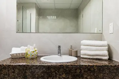a bathroom with a sink and a mirror and towels at JBR Full Sea View Apartment 1 BR in Dubai