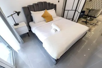 a bedroom with a large bed with white sheets and pillows at Classy and Bright - Studio - JLT in Dubai