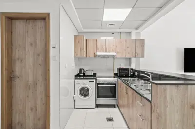 a kitchen with a washer and dryer in it at Lavish 2BR with Charming Marina View in Dubai
