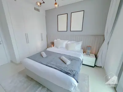 a white bedroom with a large white bed with two pillows at 2BR in Burj Crown l Pool Access & City Views in Dubai