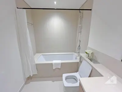 a white bathroom with a tub and a toilet at 2BR in Burj Crown l Pool Access & City Views in Dubai