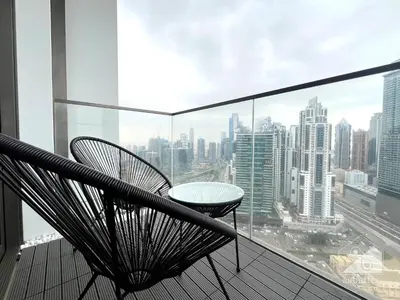 a balcony with a table and chairs and a city at 2BR in Burj Crown l Pool Access & City Views in Dubai