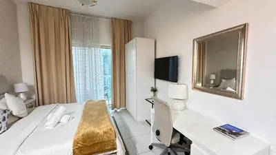 a hotel room with a bed and a desk and a mirror at Spontaneous Sea View and High floor Studio Apartment in Dubai