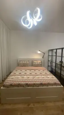 a bedroom with a bed with a chandelier above it at A chilled place JVC in Dubai