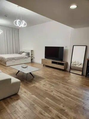 a living room with a couch and a flat screen tv at A chilled place JVC in Dubai