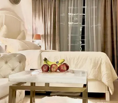 a plate of apples and bananas on a table in a living room at Dubai Galaxy in Azizi Riviera Luxury Studio in Dubai