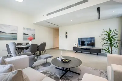 a living room with a couch and a table at Spacious apartment with Maid room in Dubai Marina I Marina Arcade in Dubai