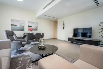 a living room with a couch and a table and a television at Spacious apartment with Maid room in Dubai Marina I Marina Arcade in Dubai