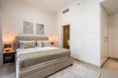 a white bedroom with a large bed and a mirror at Spacious apartment with Maid room in Dubai Marina I Marina Arcade in Dubai