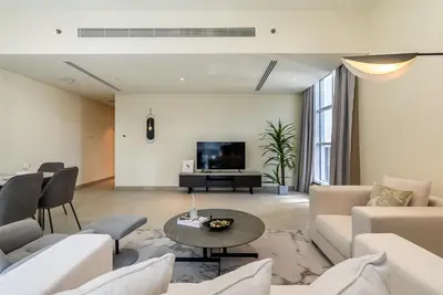 a living room with white furniture and a tv at Spacious apartment with Maid room in Dubai Marina I Marina Arcade in Dubai