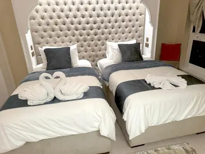 two swans are sitting on two beds in a bedroom at ROYAL BEACH RESIDENCES 2 in Dubai