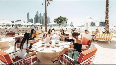 a group of women sitting at a table on a deck at Five Palm Residences 2 Bedroom Apt in Dubai