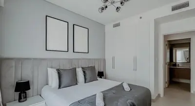 a bedroom with a large bed with two pictures on the wall at Burj Crown Luxurious 2Bedroom Balcony in Dubai