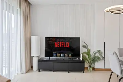 a living room with a tv and a table at Hidden Gem, Waterfront Escape With Harbor View in Dubai