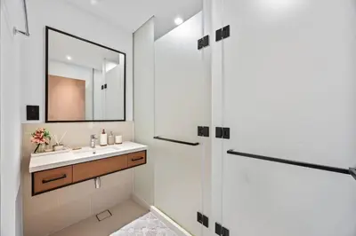 a white bathroom with a sink and a mirror at Hidden Gem, Waterfront Escape With Harbor View in Dubai