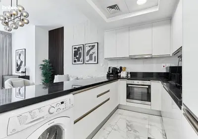 a kitchen with white cabinets and a dishwasher at bnbme - Premium 1BR Apt Balcony Pool Gym Parking Near Dubai Mall & Burj Khalifa in Dubai