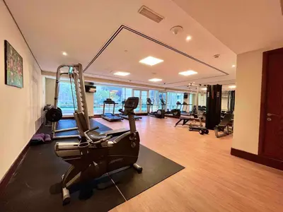 a gym with treadmills and exercise equipment in a room at Rustic Elegance By The Lake Studio Cabin In Jlt in Dubai
