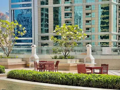 a group of chairs and a table in front of a building at Rustic Elegance By The Lake Studio Cabin In Jlt in Dubai