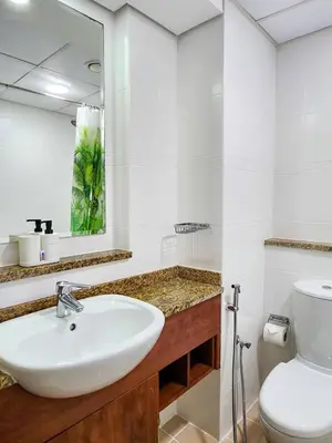 a white bathroom with a sink and a toilet at Rustic Elegance By The Lake Studio Cabin In Jlt in Dubai