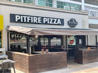 a pitt fire pizza restaurant with a sign on it at Rustic Elegance By The Lake Studio Cabin In Jlt in Dubai
