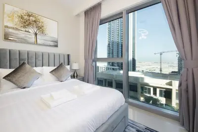 a bedroom with a large window with a view of a city at Elegant Waterfront 1BHK in Dubai Creek Harbour in Dubai