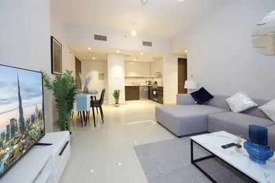 a living room with a couch and a tv and a table at Elegant Waterfront 1BHK in Dubai Creek Harbour in Dubai