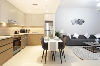 a kitchen and living room with a table and a couch at Elegant Waterfront 1BHK in Dubai Creek Harbour in Dubai