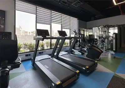 a gym with two treadmills and two laptops in it at HAVN - Studio in MYKA, Near Meaisem City Center in Dubai