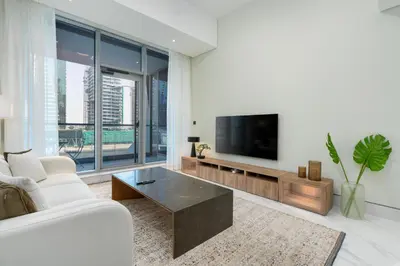a living room with a white couch and a tv at Vacay Lettings 1 bed Business home in J One Tower Business bay in Dubai