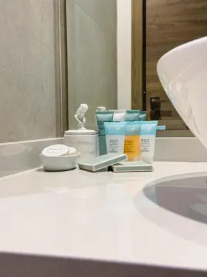 a bathroom counter with moisturizers and other products on it at Naseem - Studio One Tower in Dubai
