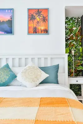 a bedroom with a white bed with blue and orange pillows at Jlt Spacious Corner Duplex Loft Panoramic Views in Dubai
