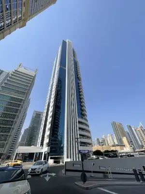 a tall building with cars parked in a parking lot at Spacious Jlt High Floor Studio Wstunning Views in Dubai