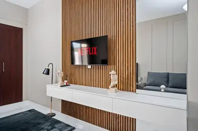 a living room with a tv on a wooden wall at Newly Built Studio - Comfort in Dubai