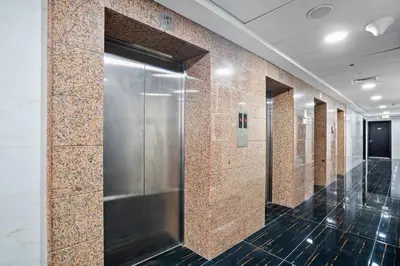a row of stalls in a restroom with a metal elevator at Newly Built Studio - Comfort in Dubai