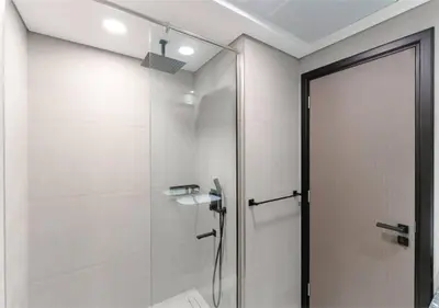 a shower with a glass door in a bathroom at HAVN - Studio Apartment in Chaimaa Avenue, JVC in Dubai