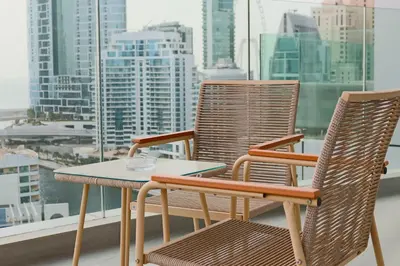 two chairs and a table on a balcony with a city at Casa Royale Vacation Home - Dubai Marina in Dubai