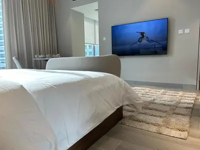 a bedroom with a bed and a tv on a wall at Casa Royale Vacation Home - Dubai Marina in Dubai