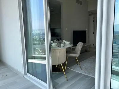 a dining room with a table and a large window at Casa Royale Vacation Home - Dubai Marina in Dubai