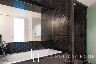 a bathroom with a bath tub and a mirror at LUX The Elegant DIFC Suite 2 in Dubai