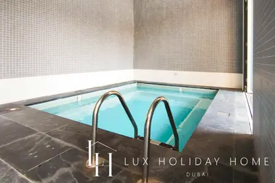 a hot tub in a bathroom with two faucets at LUX The Elegant DIFC Suite 2 in Dubai