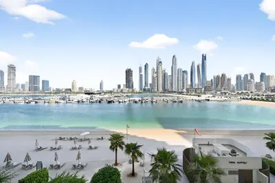 a view of a beach with a city in the background at Seascape Sanctuary - 3 and a Half BR Beachfront Bliss - Marina Vista Tower 1 in Dubai