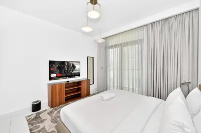 a bedroom with a bed and a flat screen tv at Seascape Sanctuary - 3 and a Half BR Beachfront Bliss - Marina Vista Tower 1 in Dubai
