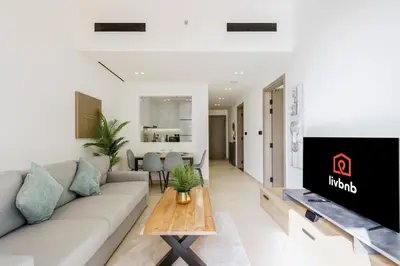 a living room with a couch and a table at Chic 1BR in JVC with Balcony, Near Mall & Parks in Dubai