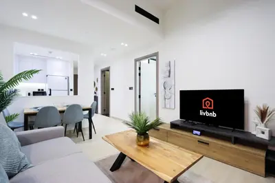 a living room with a tv on a wall at Chic 1BR in JVC with Balcony, Near Mall & Parks in Dubai