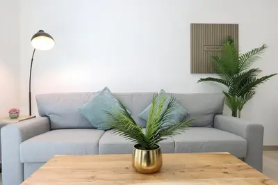 a living room with a couch and a table at Chic 1BR in JVC with Balcony, Near Mall & Parks in Dubai