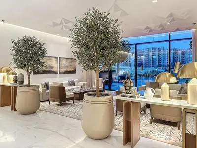 a living room with two trees in large vases at Lux 1BR Apartment with Amazing view in Palace Residences Creek Harbor in Dubai