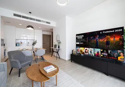 a living room with a large flat screen tv on a wall at Lux 1BR Apartment with Amazing view in Palace Residences Creek Harbor in Dubai