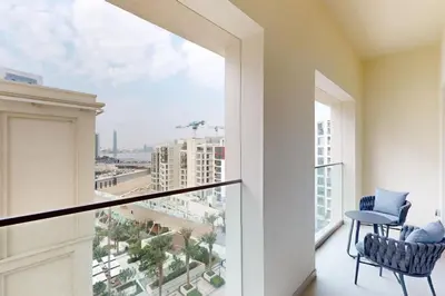 a balcony with two chairs and a view of a city at Vida Residences at Creek Beach - Light Two Bedroom in Dubai