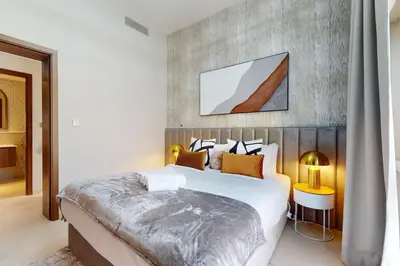 a bedroom with a large bed with a wooden headboard at Vida Residences at Creek Beach - Light Two Bedroom in Dubai