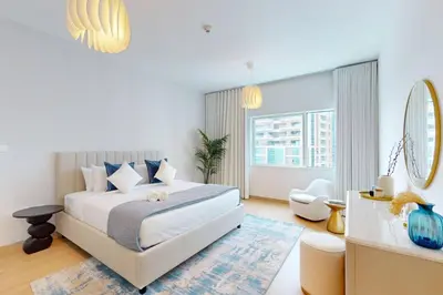 a white bedroom with a bed and a large window at MAG 218 Tower - Elegant One Bedroom in Dubai